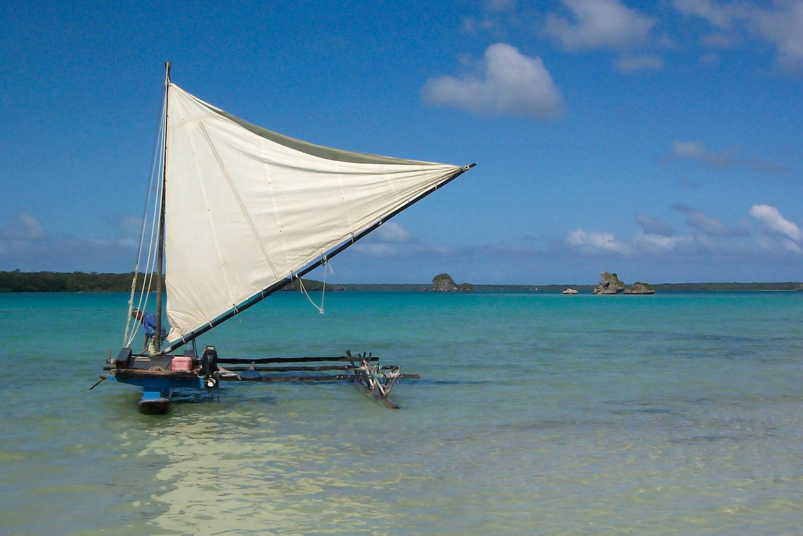 Traditional sailing pirogue on New Caledonia's turquoise lagoon
